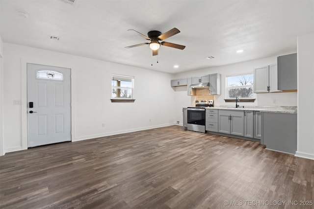 kitchen featuring dark wood finished floors, gray cabinets, stainless steel range with electric cooktop, a sink, and under cabinet range hood