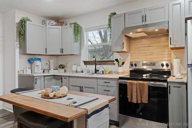 kitchen featuring wooden counters, electric range, gray cabinetry, a sink, and under cabinet range hood