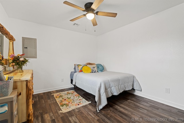 bedroom featuring baseboards, wood finished floors, visible vents, and electric panel