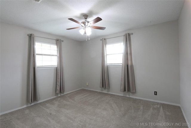 carpeted empty room featuring ceiling fan and a textured ceiling