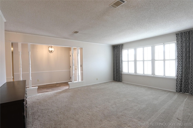 carpeted empty room with a textured ceiling, visible vents, and baseboards