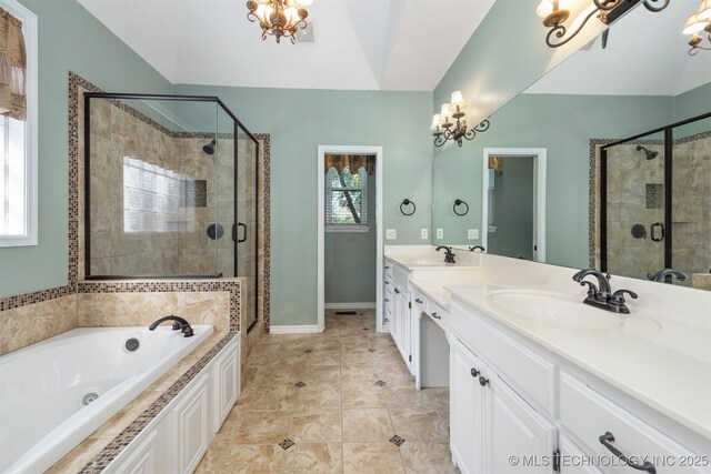 full bathroom with a chandelier, a jetted tub, a sink, and a stall shower