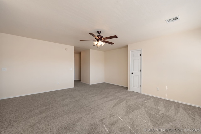 spare room with carpet floors, baseboards, visible vents, and a ceiling fan