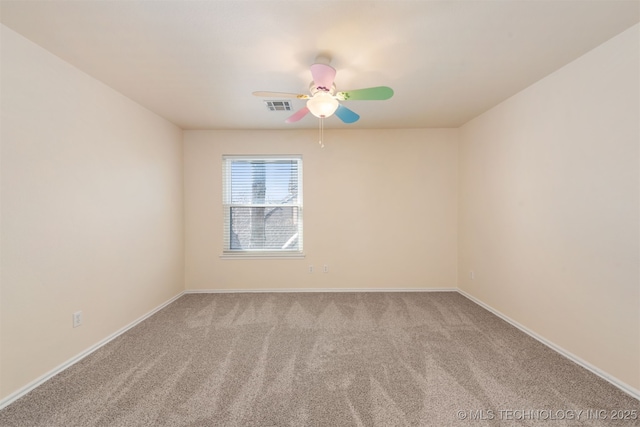 spare room with a ceiling fan, carpet, visible vents, and baseboards