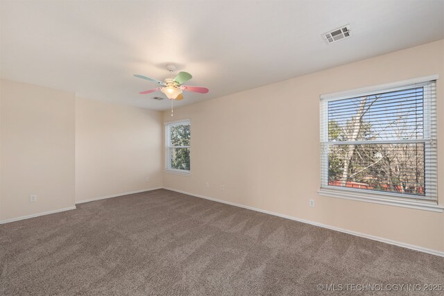 unfurnished room with a ceiling fan, carpet, visible vents, and baseboards