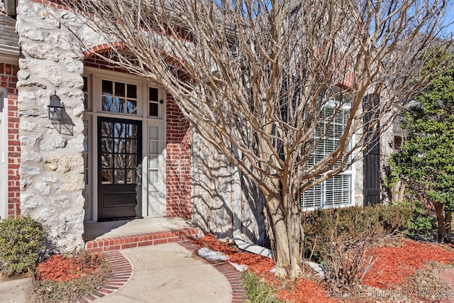 view of exterior entry with brick siding