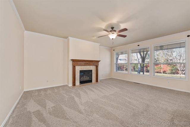 unfurnished living room featuring baseboards, a tiled fireplace, visible vents, and crown molding