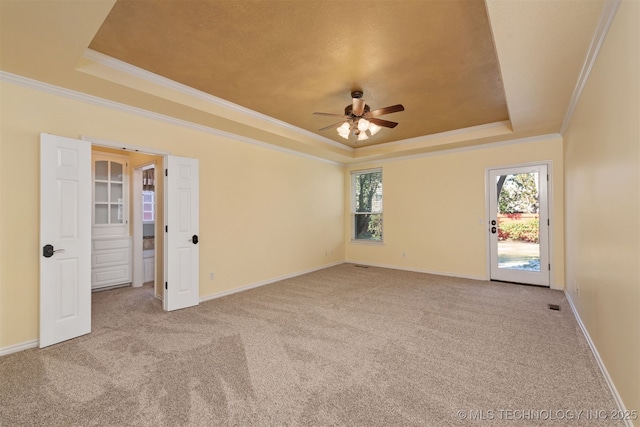 spare room featuring baseboards, a tray ceiling, ornamental molding, and light colored carpet