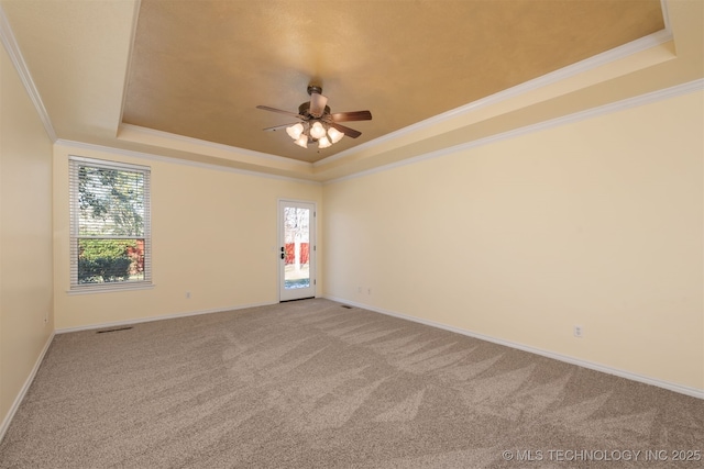 unfurnished room featuring carpet floors, ornamental molding, a raised ceiling, and baseboards