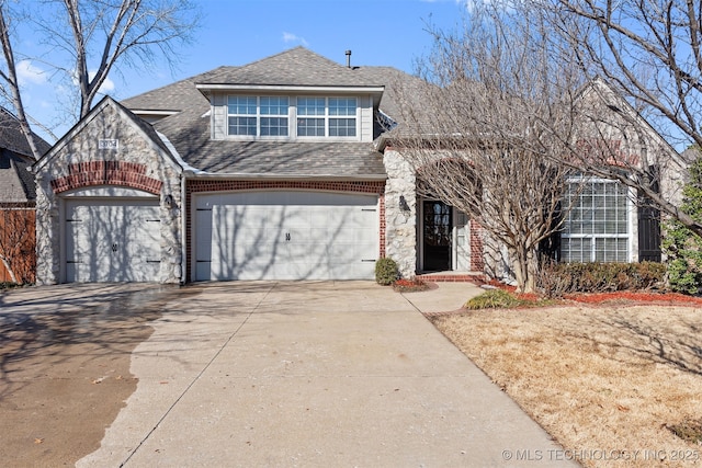 view of front facade featuring driveway, roof with shingles, and brick siding