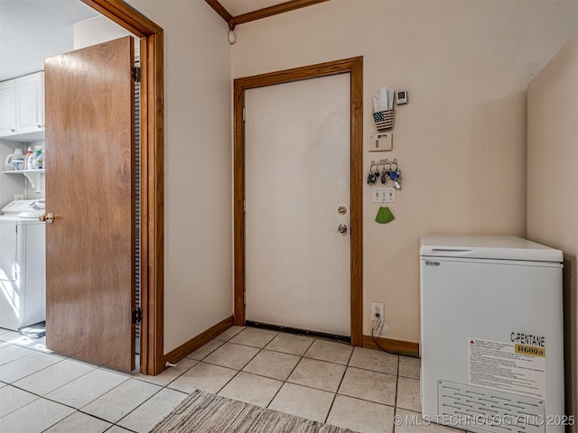 interior space with washer / dryer, light tile patterned flooring, and baseboards