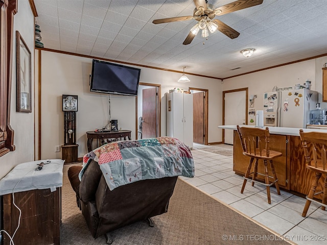 living area featuring a ceiling fan, light tile patterned flooring, crown molding, and a dry bar