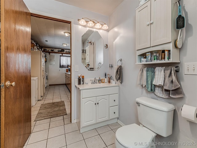 bathroom with toilet, vanity, baseboards, and tile patterned floors