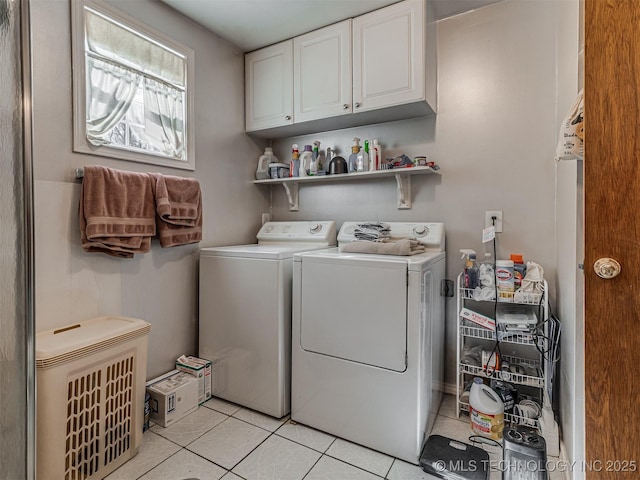 laundry room featuring washing machine and dryer, cabinet space, and light tile patterned flooring