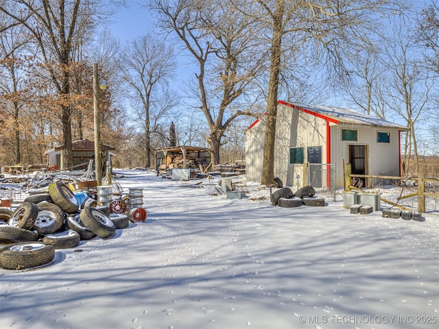 yard layered in snow featuring an outdoor structure