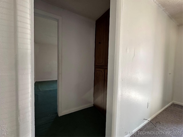 hallway with carpet floors and baseboards