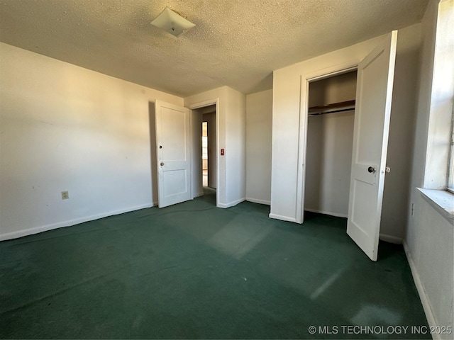 unfurnished bedroom with baseboards, a closet, dark carpet, and a textured ceiling