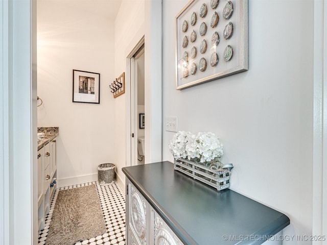 interior space featuring toilet, baseboards, and vanity