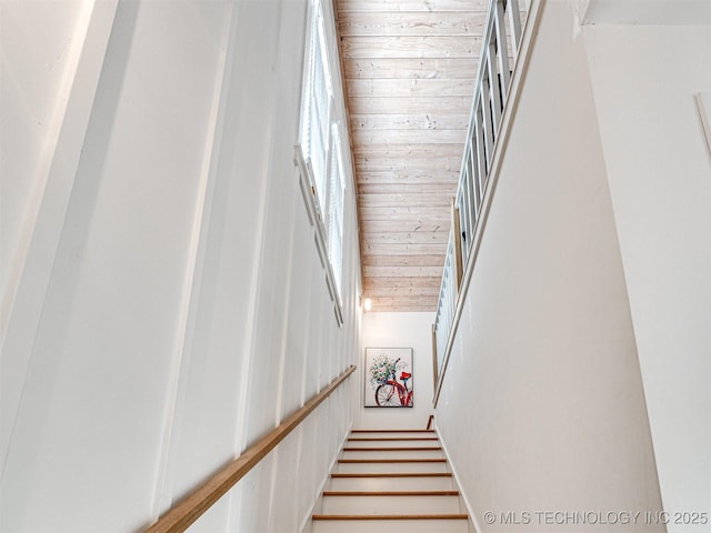 stairs featuring wood ceiling and a high ceiling