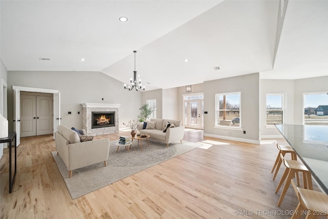 living area featuring a fireplace, recessed lighting, visible vents, light wood-style floors, and vaulted ceiling