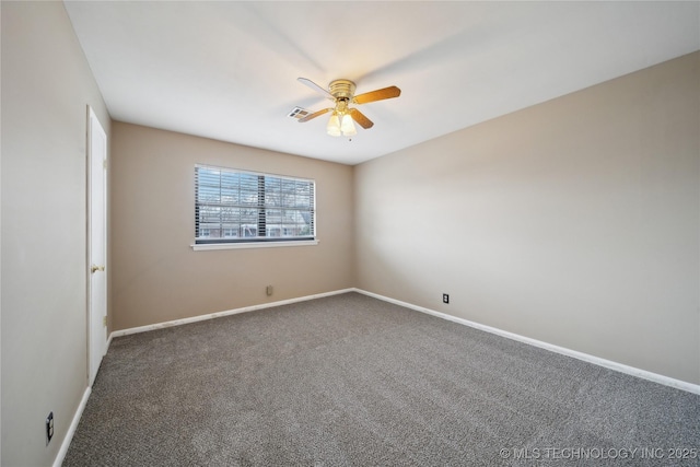 spare room featuring dark colored carpet, visible vents, ceiling fan, and baseboards