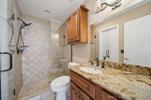 bathroom with vanity, toilet, and a shower stall