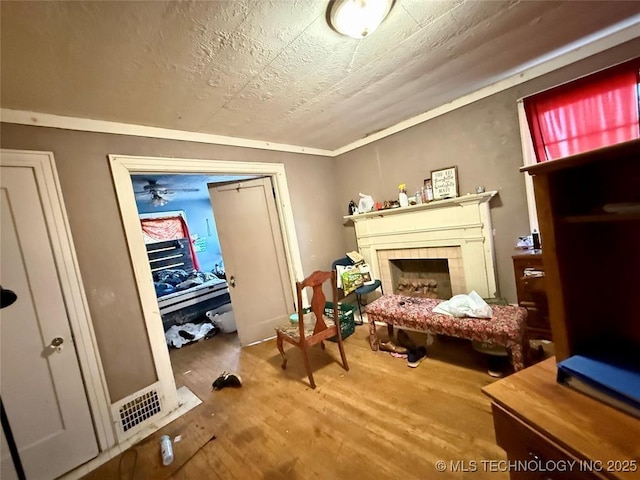 sitting room featuring a textured ceiling, a fireplace, and wood finished floors