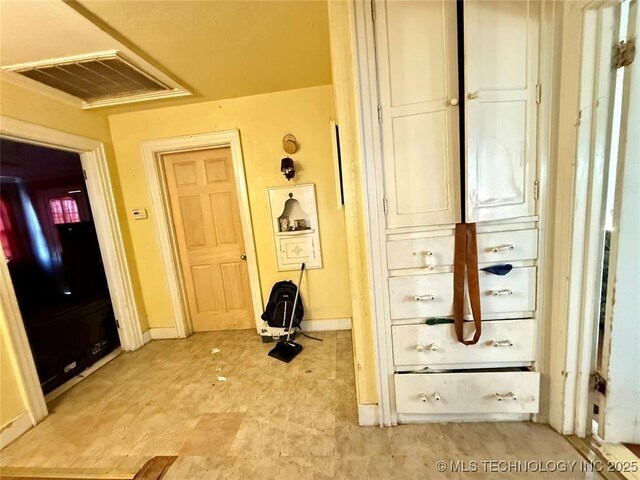 hallway with visible vents and baseboards