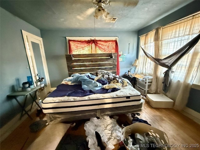 bedroom featuring visible vents and wood finished floors