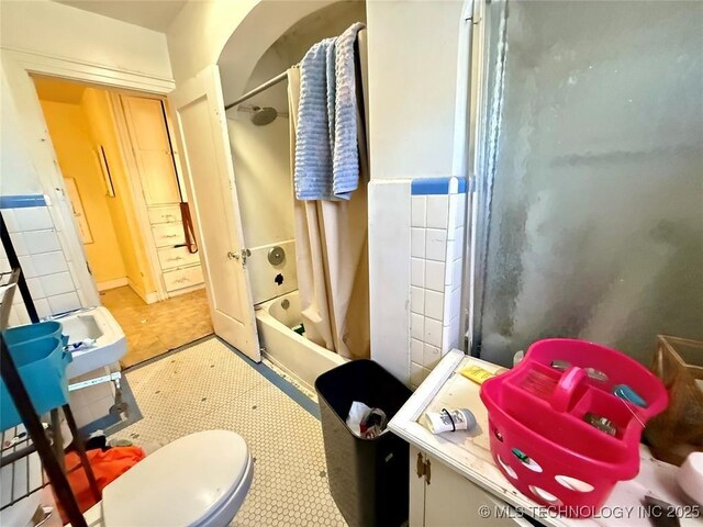 bathroom with shower / bath combo and toilet