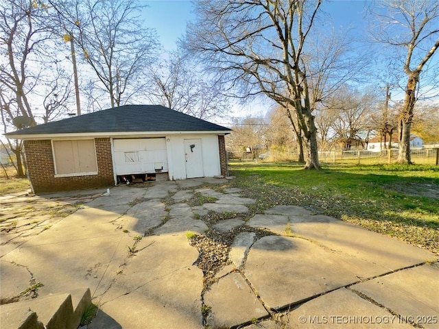 view of outdoor structure featuring driveway, an outdoor structure, and fence