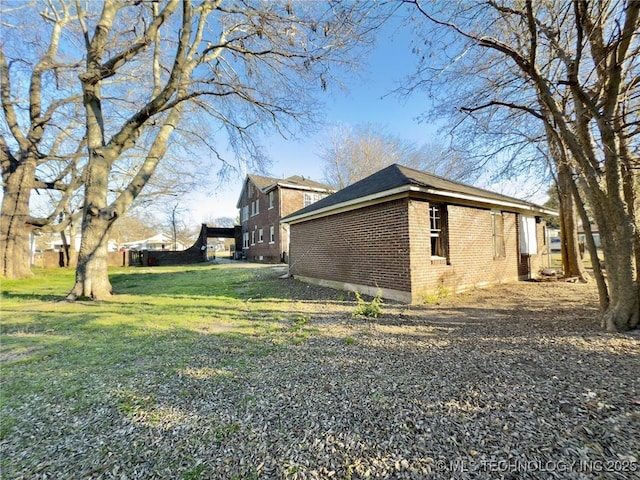 view of property exterior with a lawn and brick siding