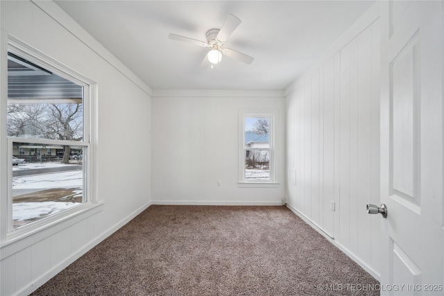 spare room with carpet floors, ceiling fan, and baseboards