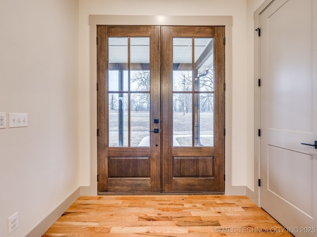 entryway featuring french doors, light wood-type flooring, and baseboards