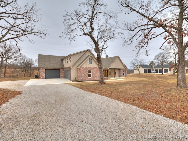 view of front of house featuring brick siding and gravel driveway