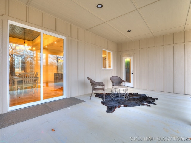 living area featuring concrete flooring and a decorative wall