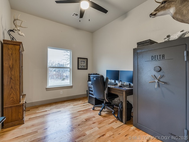 office area with light wood finished floors, baseboards, visible vents, and ceiling fan