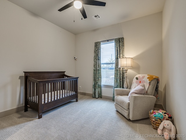 bedroom featuring light colored carpet, baseboards, visible vents, and a nursery area