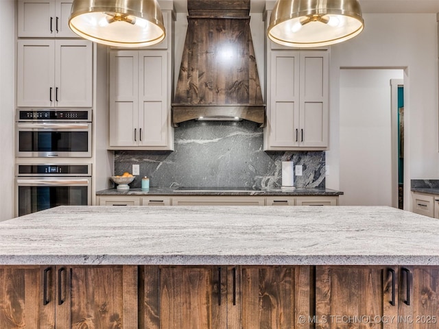 kitchen with double oven, custom range hood, black electric stovetop, and backsplash