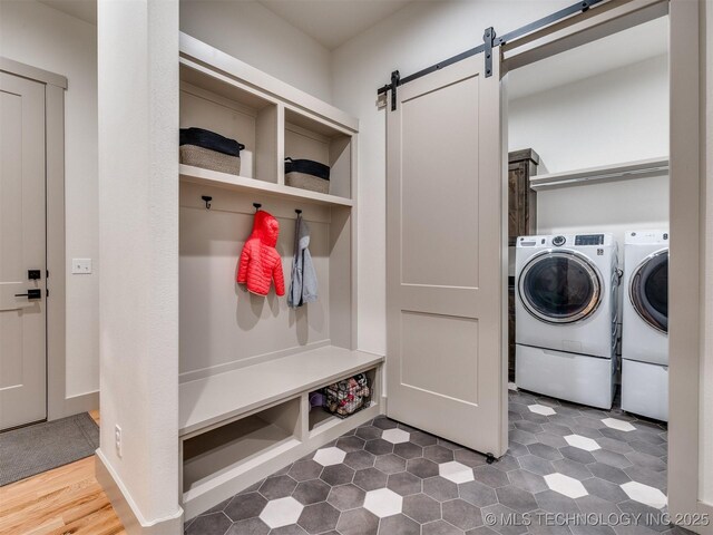 mudroom featuring a barn door and independent washer and dryer