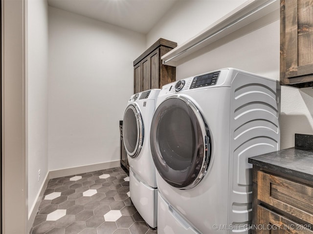 clothes washing area with cabinet space, baseboards, and washing machine and clothes dryer