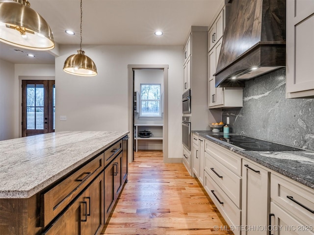 kitchen featuring white cabinets, dark stone counters, oven, custom exhaust hood, and black electric cooktop