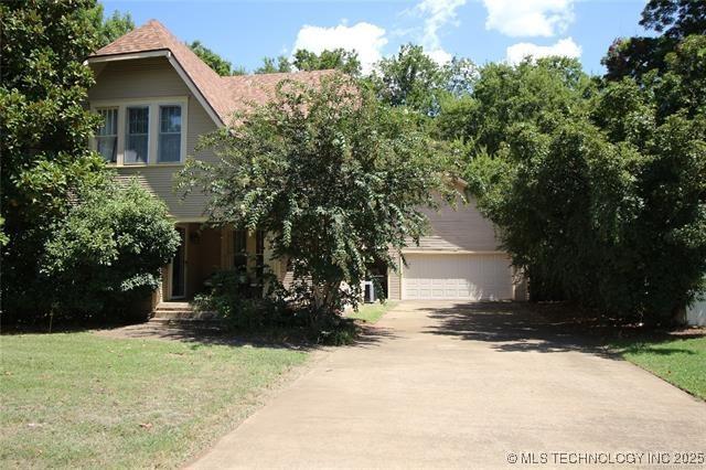 view of front of home with driveway and a front lawn