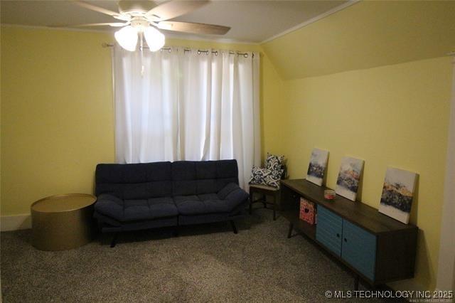 living area with vaulted ceiling, carpet, a wealth of natural light, and a ceiling fan