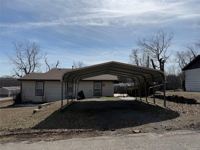 view of vehicle parking with driveway and a detached carport