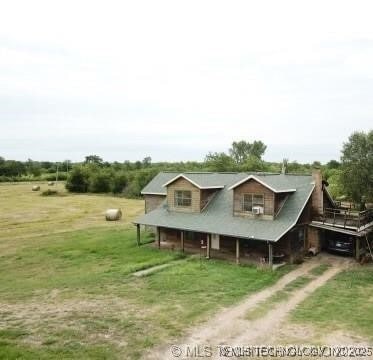 view of front of house with driveway, a front lawn, and a rural view