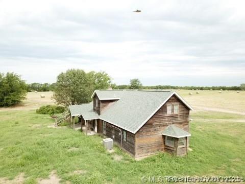 view of side of property featuring a yard, a detached garage, and driveway