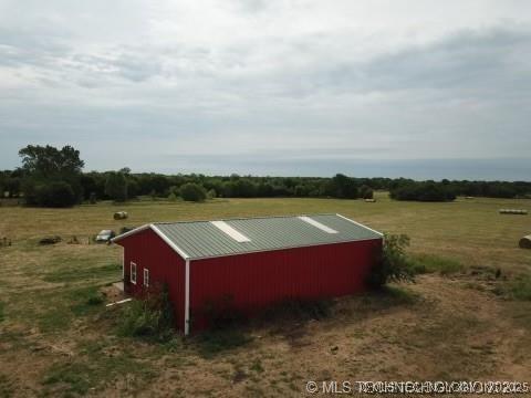 view of pole building with a yard and a rural view