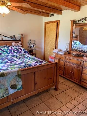 bedroom with wooden ceiling, light tile patterned floors, and beamed ceiling