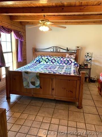 bedroom featuring wooden ceiling, ceiling fan, light tile patterned floors, and beamed ceiling